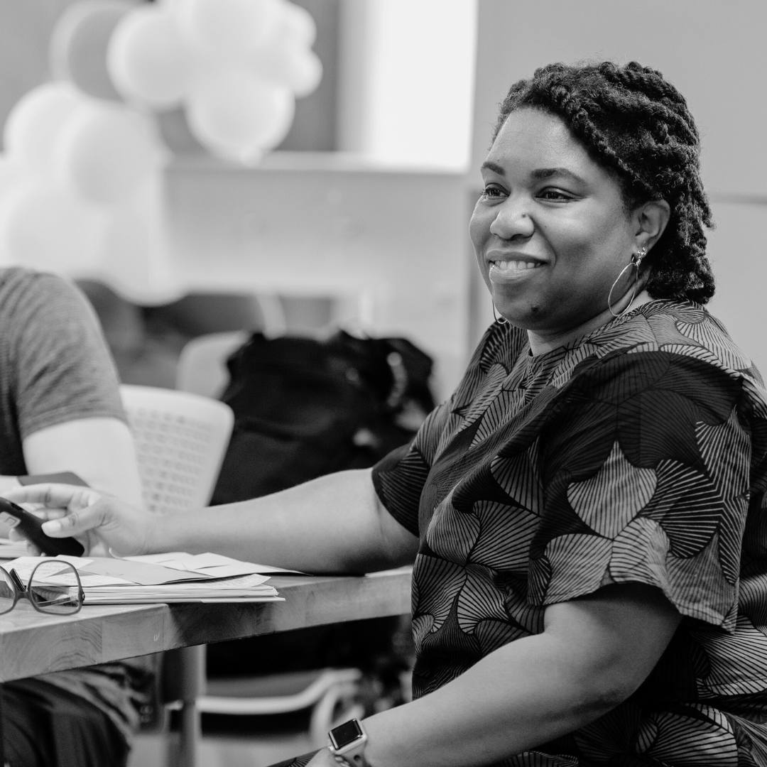 Keecha Harris & Associates team member sitting down in a chair smiling